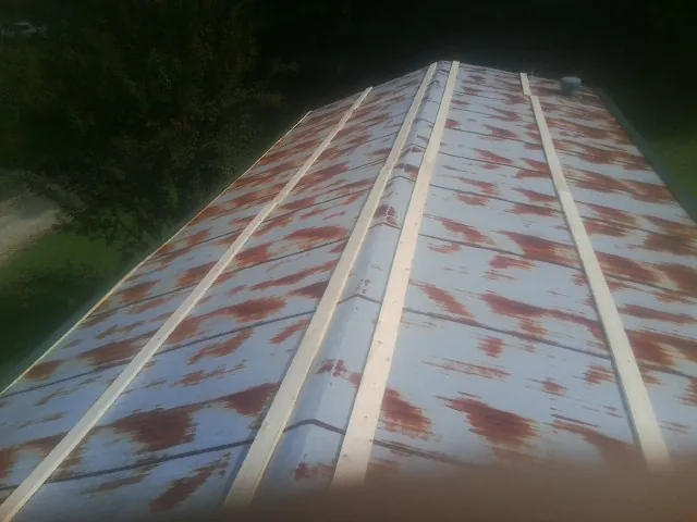 Rusted metal roof panels with new wood purlins before replacement — Storm Damage Roof Repair in Rotonda West by Roofing Brothers